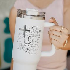 a woman holding a white coffee cup with the words she who people are god and anyone on it