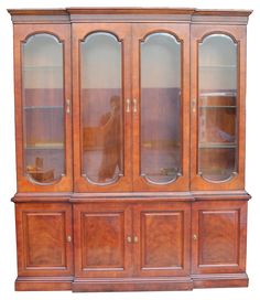 an old wooden china cabinet with glass doors