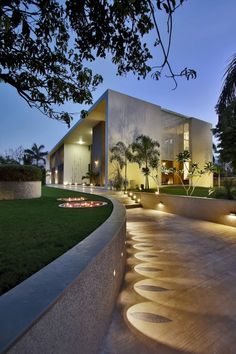 a modern house is lit up at night with lights on the front and side walls