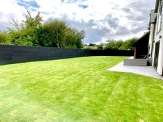 an empty backyard with grass and fenced in area