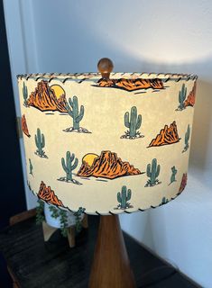 a lampshade with an image of mountains and cacti printed on it