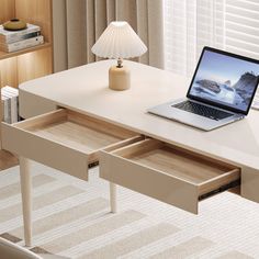 an open laptop computer sitting on top of a white desk next to a book shelf