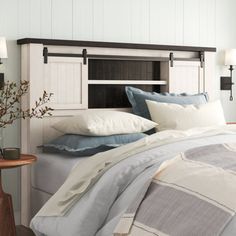 a bed with white and blue pillows in a room