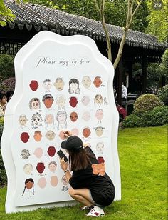 a woman is drawing on a large sign