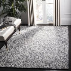 a living room area with a large rug on the floor and a window in the background