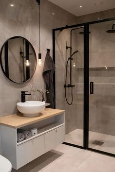 a bathroom with a sink, mirror and shower stall in it's own area