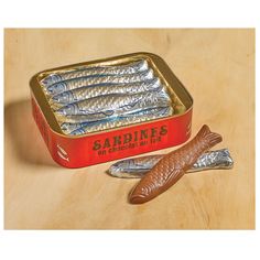 there is a tin of sardines on the table next to some fish tails