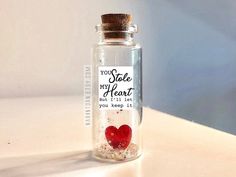 a bottle with a heart inside sitting on a table