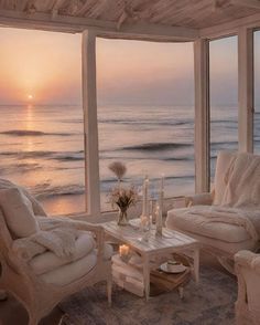 a living room filled with furniture and a view of the ocean at sunset or dawn