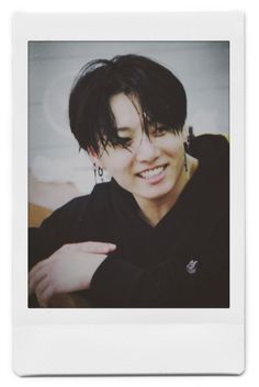 a polaroid photo of a woman with black hair and piercings smiling at the camera