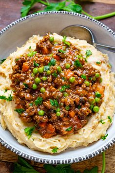 a bowl filled with mashed potatoes topped with ground beef and green onions on top