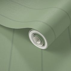 a close up view of a green wallpaper with a roll of paper in the middle