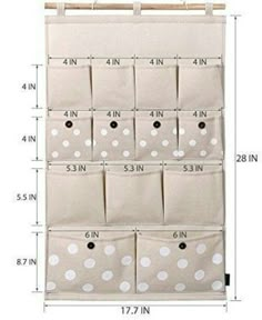 the hanging storage bag with polka dots on it is shown in white and has four pockets for