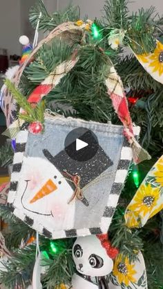 an ornament hanging from a christmas tree with snowmen and birds on it