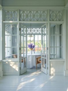 an open door leading to a dining room with white walls and flooring on the outside