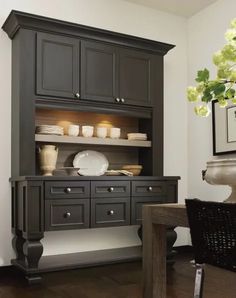 a dining room with black cabinets and wooden floors