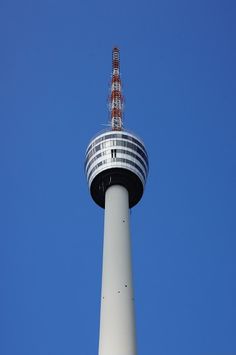 the top of a tall tower with a radio signal on it's side against a blue sky