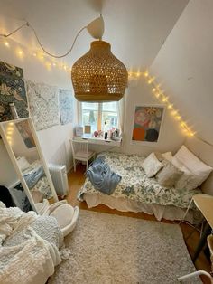 a bedroom with two beds, a desk and a mirror in the corner that is lit up by fairy lights