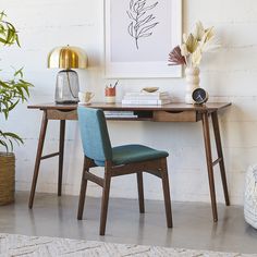 a desk with two chairs and a plant on it in front of a white brick wall