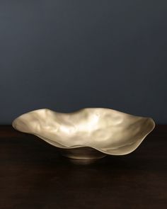 a large metal bowl sitting on top of a wooden table