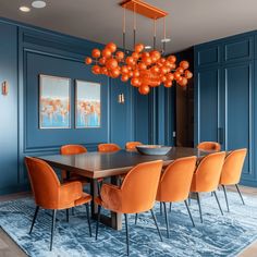 a dining room with blue walls and orange chairs