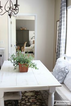 a dining room table with a potted plant on top of it in front of a doorway