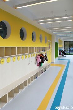 there is a coat rack in the middle of an empty room with yellow and blue stripes