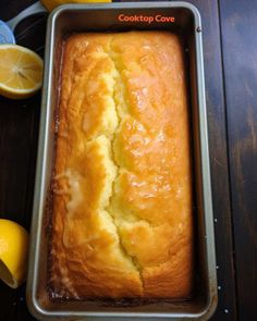 a loaf of lemon pound cake sitting in a pan on top of a wooden table