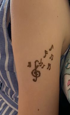 a woman's arm with musical notes on it and the word music written in cursive writing