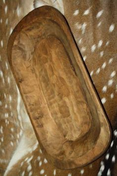 the back end of a brown and white spotted horse's head with a wooden seat