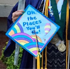 a person wearing a graduation cap and gown holding a sign that says on the places you go