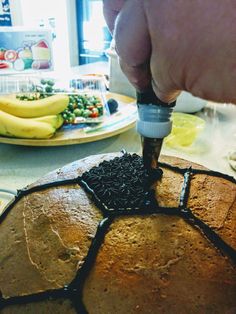 a person is cutting into a cake with chocolate frosting and sprinkles