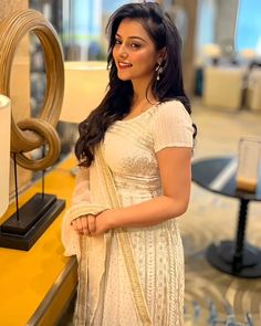 a woman in a white sari posing for the camera