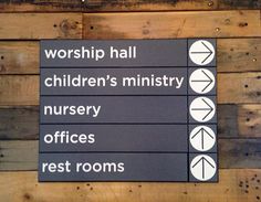 a sign that is on the side of a wooden wall saying worship hall children's minister nursery nursery offices rest rooms