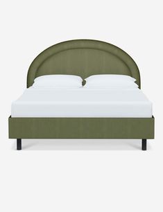 a bed with a green headboard and white sheets