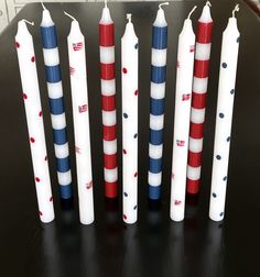 several red, white and blue toothbrushes lined up in rows on a black surface