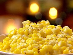 a white bowl filled with corn on top of a table