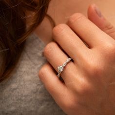 a woman's hand with a diamond ring on it