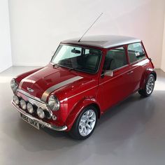 a small red car parked in a white room