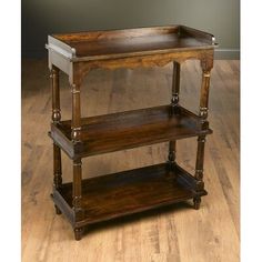 an old wooden shelf with three shelves on it's sides, sitting on a hard wood floor