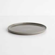 a round metal tray on a white surface with no one around it or someone else