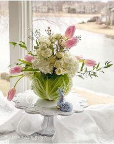 a vase filled with flowers sitting on top of a table next to a window sill