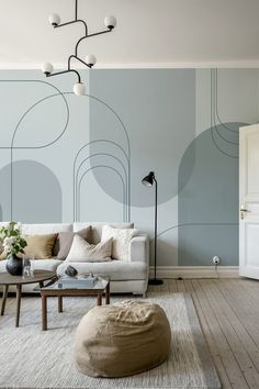 a living room with a couch, chair and coffee table in front of a blue wall