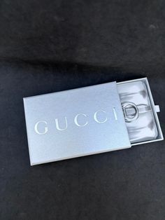 an open gucci watch box on a black surface