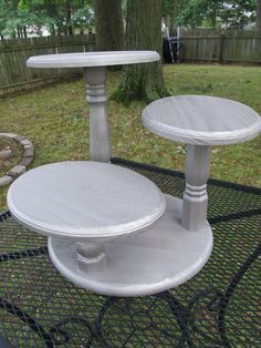 two white cake stands sitting on top of a table