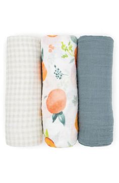 three baby swaddles are lined up in different colors and patterns, one is blue, the other has oranges