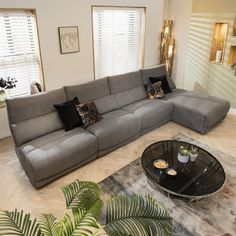 a living room with a large sectional couch and coffee table in it's center