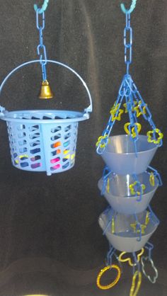 two bird feeders are hanging from chains