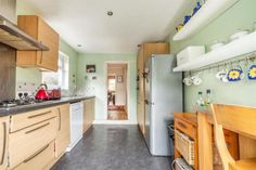 a kitchen with green walls and wooden cabinets