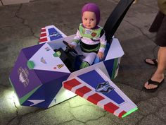 a small child sitting in a toy plane shaped like a box with skis on it